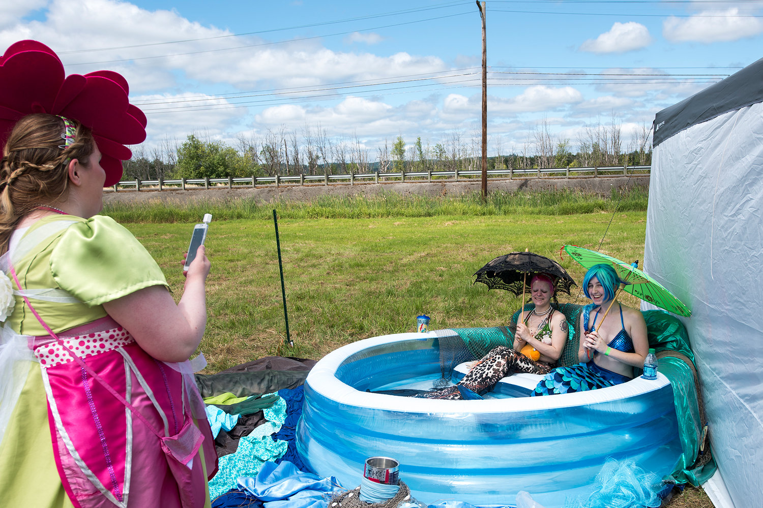 Tana Savage, playing the Sirena The Mermaid, right, and Mermaid Miyu, center, have their photo taken by Melanie Hall, of Milton, Wash., during the Fairy Blossom Festival on Saturday afternoon at Yard Birds in Chehalis.