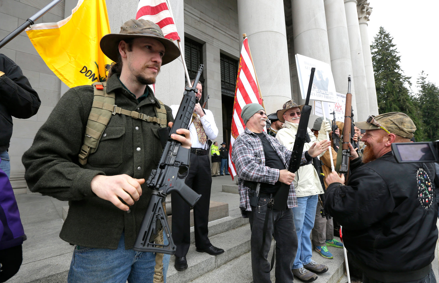 Gun owners display their weapons on the steps of the Legislative Building during a gun-rights rally, Thursday, Jan. 15, 2015, at the Capitol in Olympia, Wash. The protestors were demonstrating against the state's Initiative 594, which requires - with only a few exceptions - background checks on all gun sales and transfers. (AP Photo/Ted S. Warren)