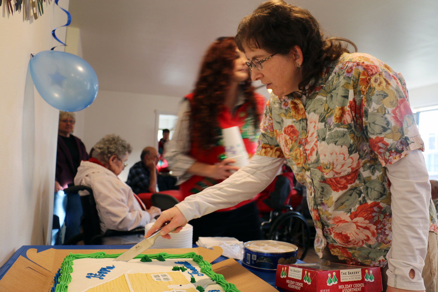 Jeannette Southmayd cuts the cake at the turnover ceremony of her new home on Saturday. Southmayd and her husband Jim were selected to receive a house built in Chehalis by the Greater Lewis County Habitat for Humanity.