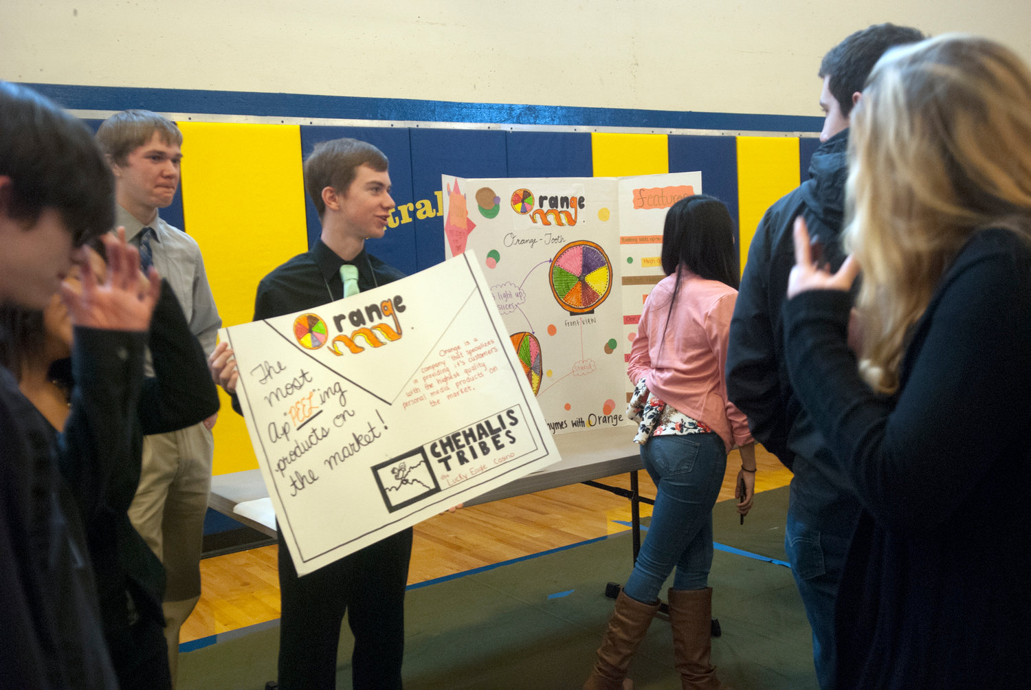 Colton Pruitt, of W.F. West, holds a sign advertising his company’s product, an “Orange-Tooth” speaker, during the trade show portion of Washington Business Week Thursday. More than 400 juniors from Centralia and W.F. West high schools participated in the annual four-day event.