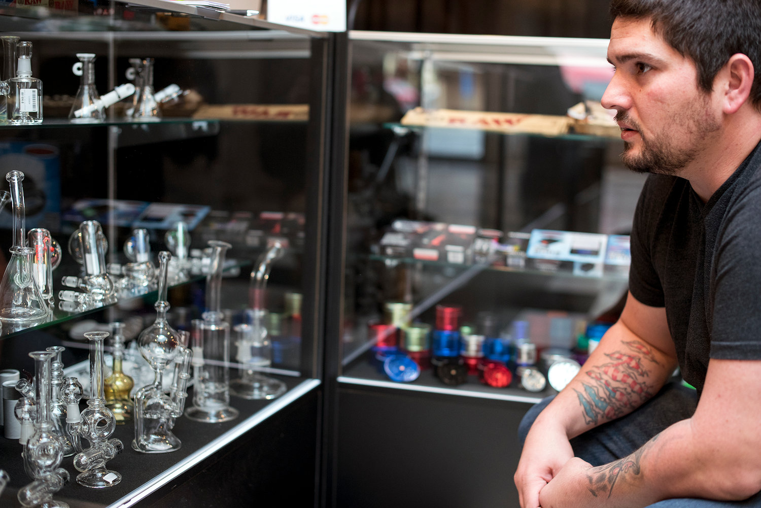 Peter Jacobsen, part-owner of The Jackal, looks at a glass case holding a plethora of a variety pipes on Tuesday, Nov. 24, at his shop in downtown Chehalis.