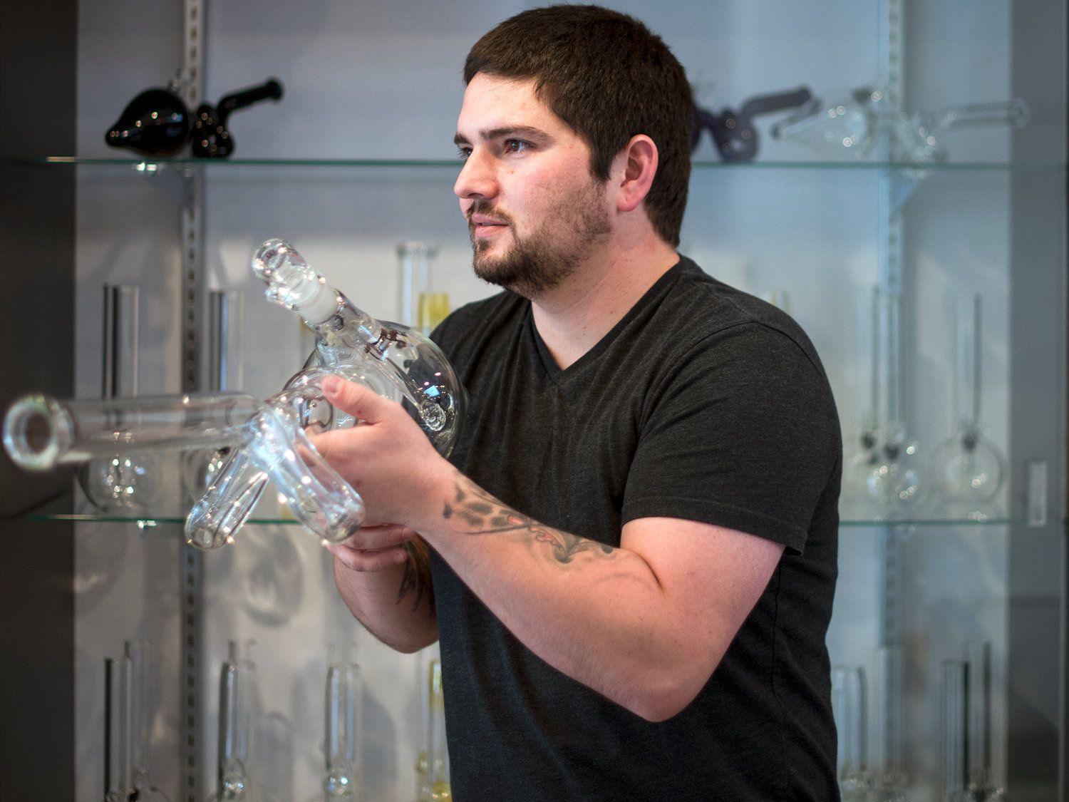 Peter Jacobsen, part-owner of The Jackal, shows off an expensive glass bong that is in the shape of a gun on Tuesday, Nov. 24, at their downtown Chehalis shop.