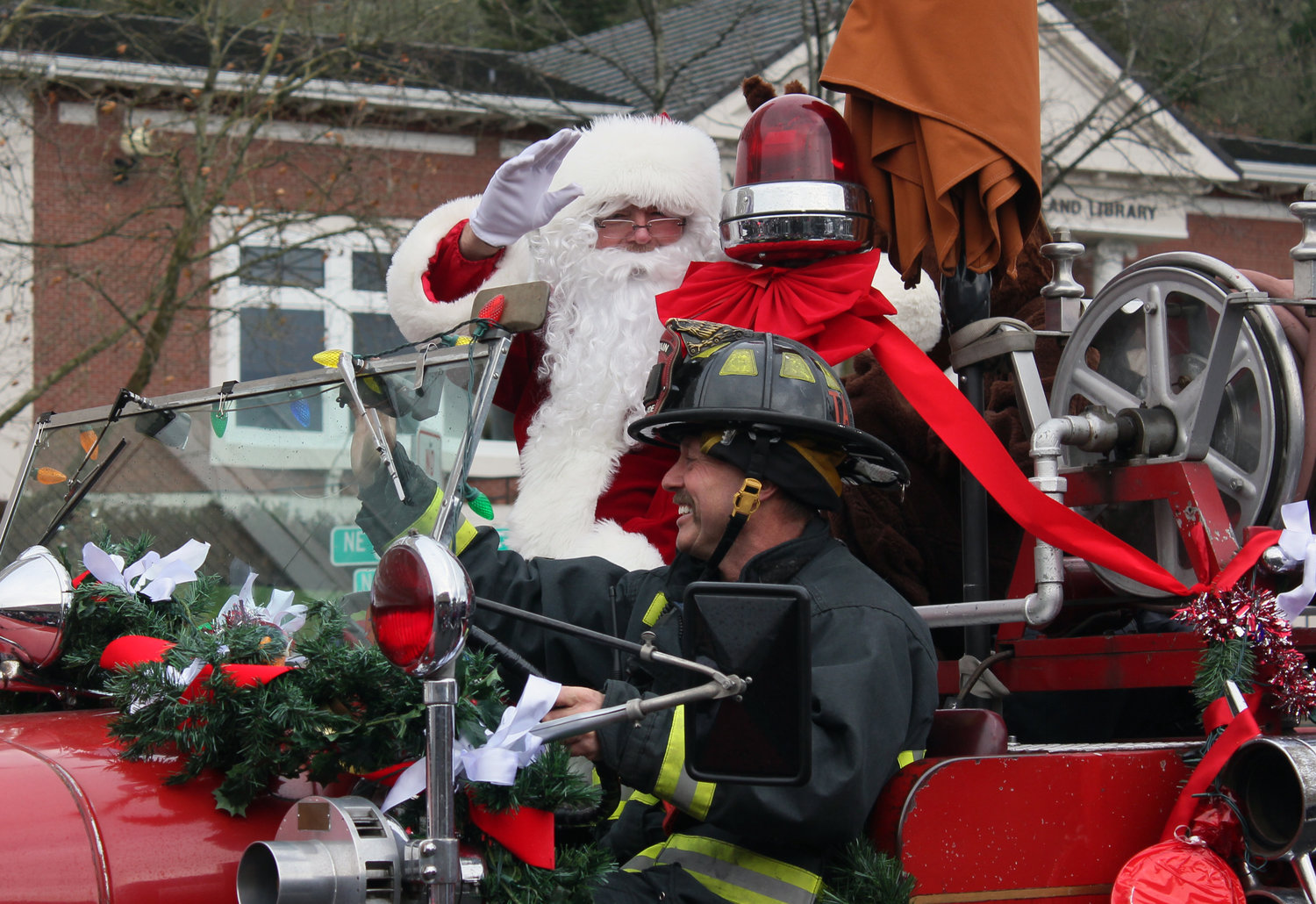 Santa Claus waves to the crowd from his perch on Riverside Fire Authority's old Engine No. 4 in downtown Chehalis on Saturday.