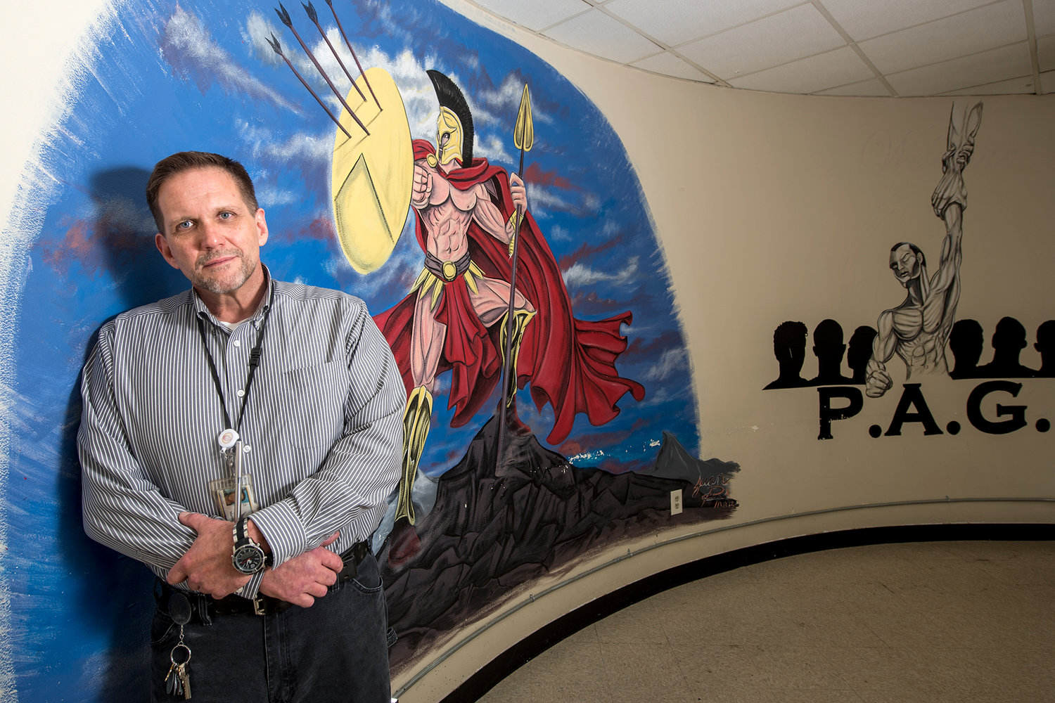 Martin Montague, the lead counselor at American Behavioral Health Systems, poses for a portrait in front of a painting of a Spartan on Wednesday afternoon in one of the meeting rooms at the Chehalis facility. Five years ago when Montague asked his clients to name their group, they came up with Martin's Spartans. Montague explained that he has always thought his clients chose Spartans because of their battles with addiction.
