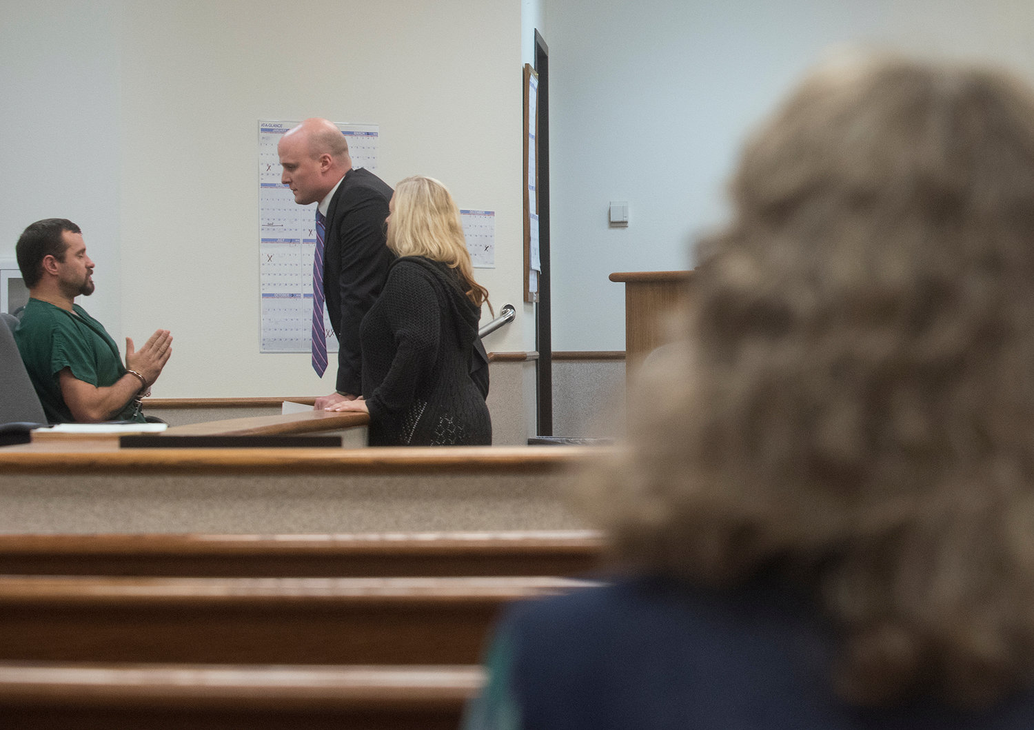 James W. McMillion, left, talks with his attorney, Brian Gerhart, as a court-appointed sign-language interpreter looks on while McMillion's mother, Gail Goodwin, right, sits in the gallery of a Lewis County Superior Court room on Wednesday afternoon prior to the start of McMillion's change-of-plea hearing at the Lewis County Law and Justice Center in Chehalis.