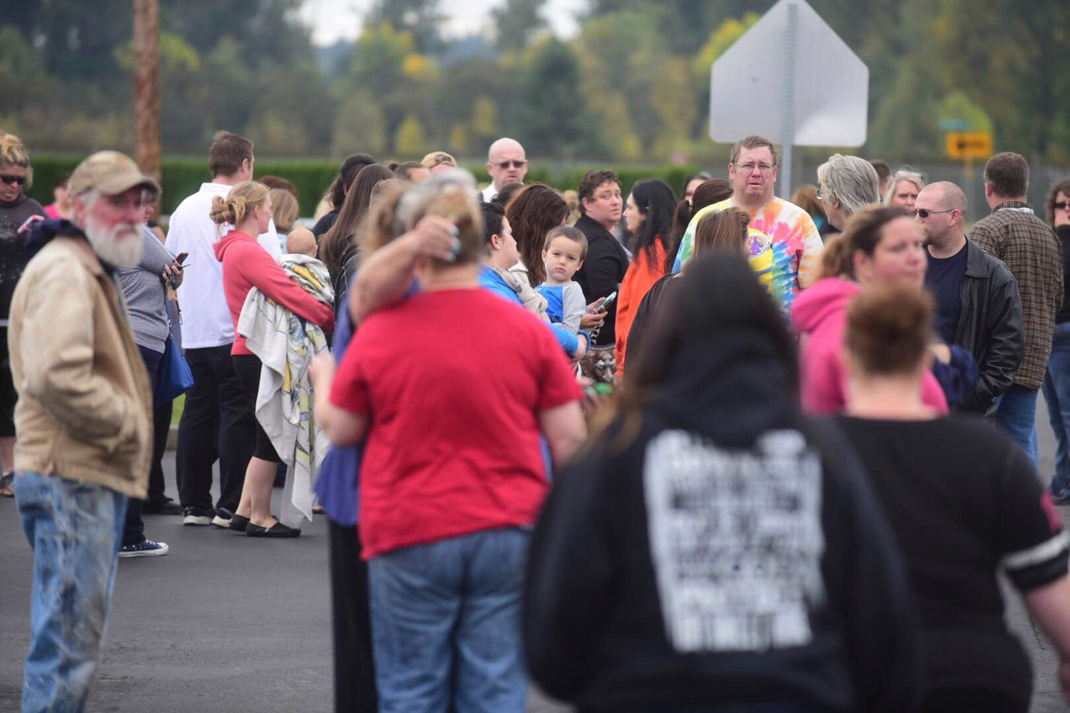 Parents and family members of students and others wait for information while standing across the street from Centralia High School Friday morning. 