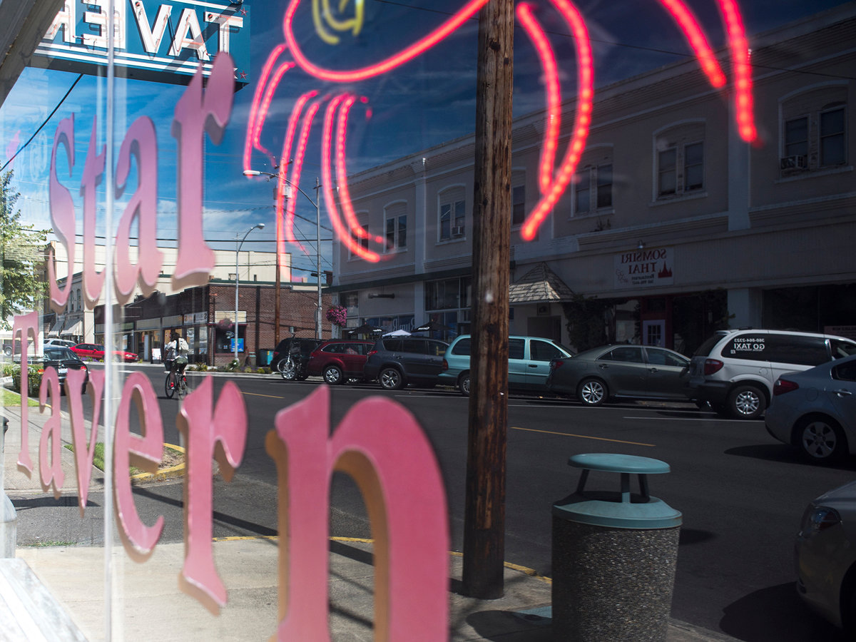 A cyclist is seen in the reflection of the front window of the Star Tavern in Chehalis on Monday afternoon.