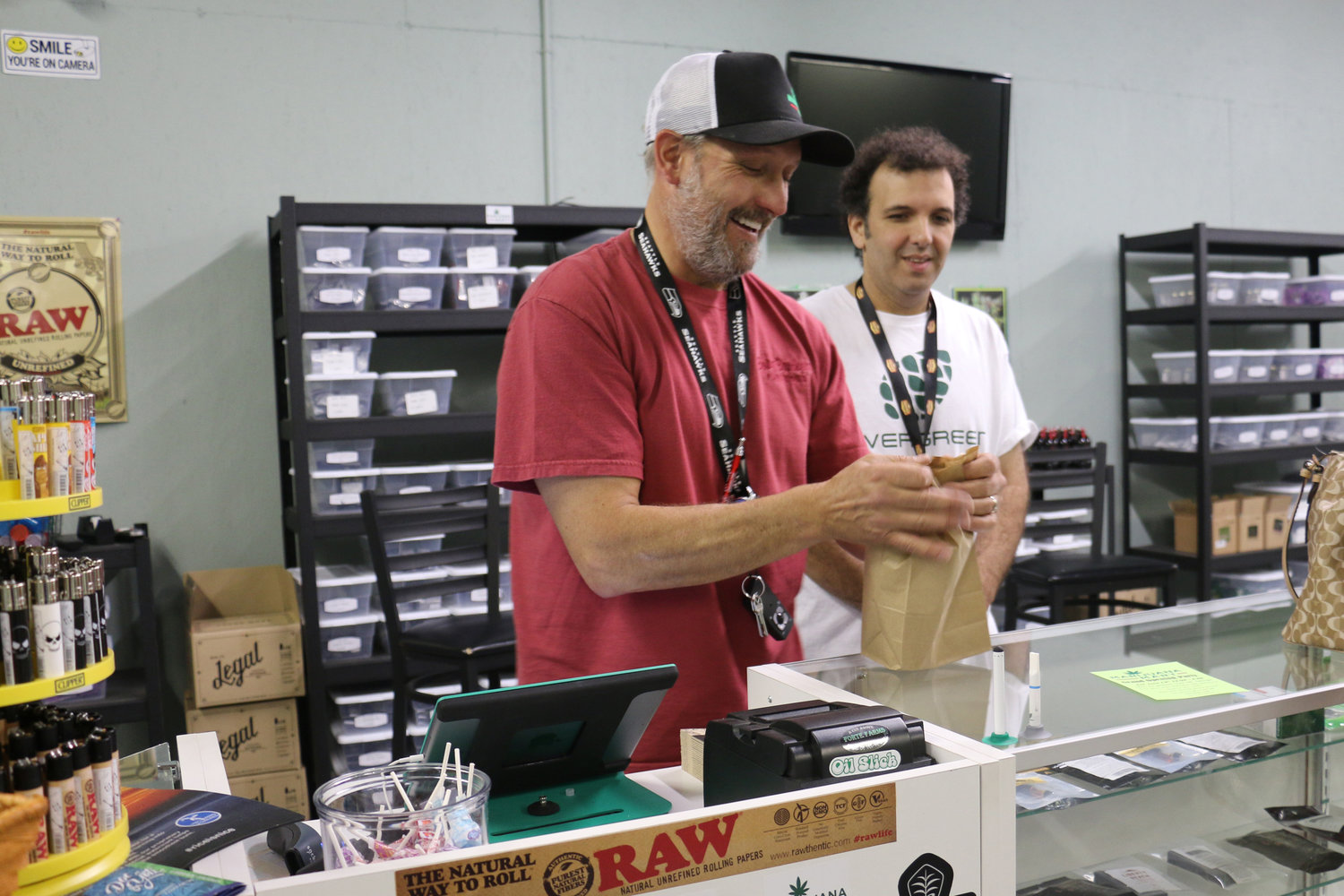 Derek Wilmot and Mike Trobman, two of the three business partners at Marijuana Mart, help a customer in June 2015. The shop was the first recreational marijuana business to open in Grand Mound.