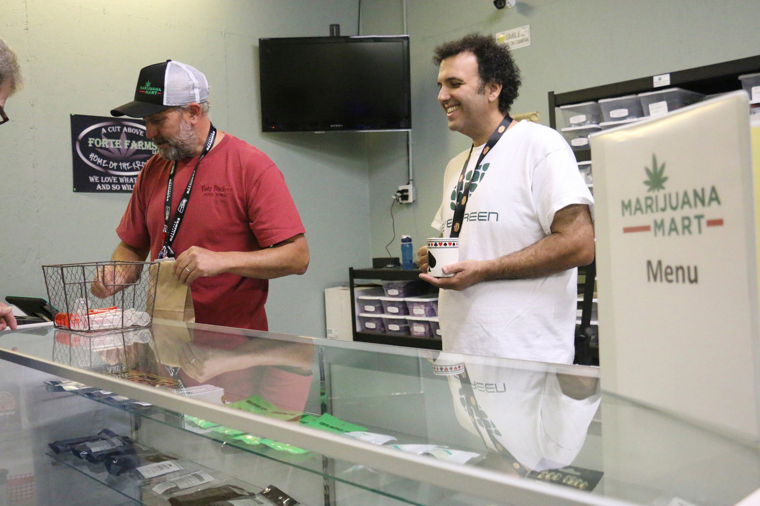 Business partners Derek Wilmot and Mike Trobman help a customer at Marijuana Mart in June 2015. The shop was the first recreational marijuana business to open in Grand Mound.