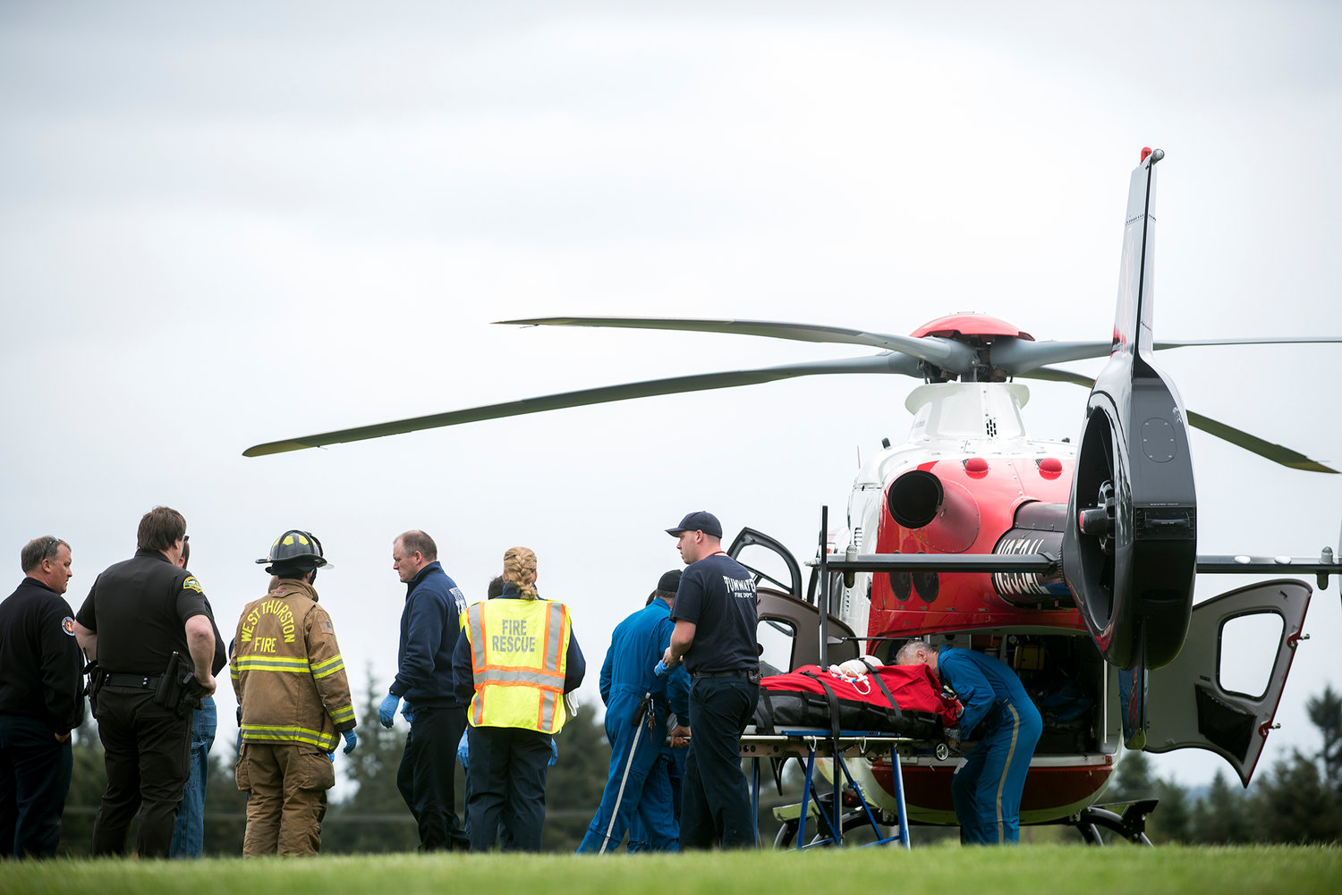 A 73-year-old man who crash landed his plane into a field in Grand Mound on Tuesday afternoon is loaded onto a MedicOne helicopter at Rochester High School prior to being transported to Harborview Medical Center in Seattle. According to the West Thurston County Fire Department, the man was in stable condition after being pulled from the cockpit of the plane.