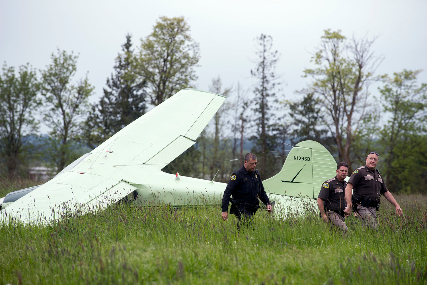 Personal from the Thurston County Sheriff's Department leave the scene of a crash landing on Tuesday afternoon in a field off of Oregon Trail Road in Grand Mound. A 73-year-old man piloted the plane to the ground and was flown to Harbourview Medical Center in stable condition.