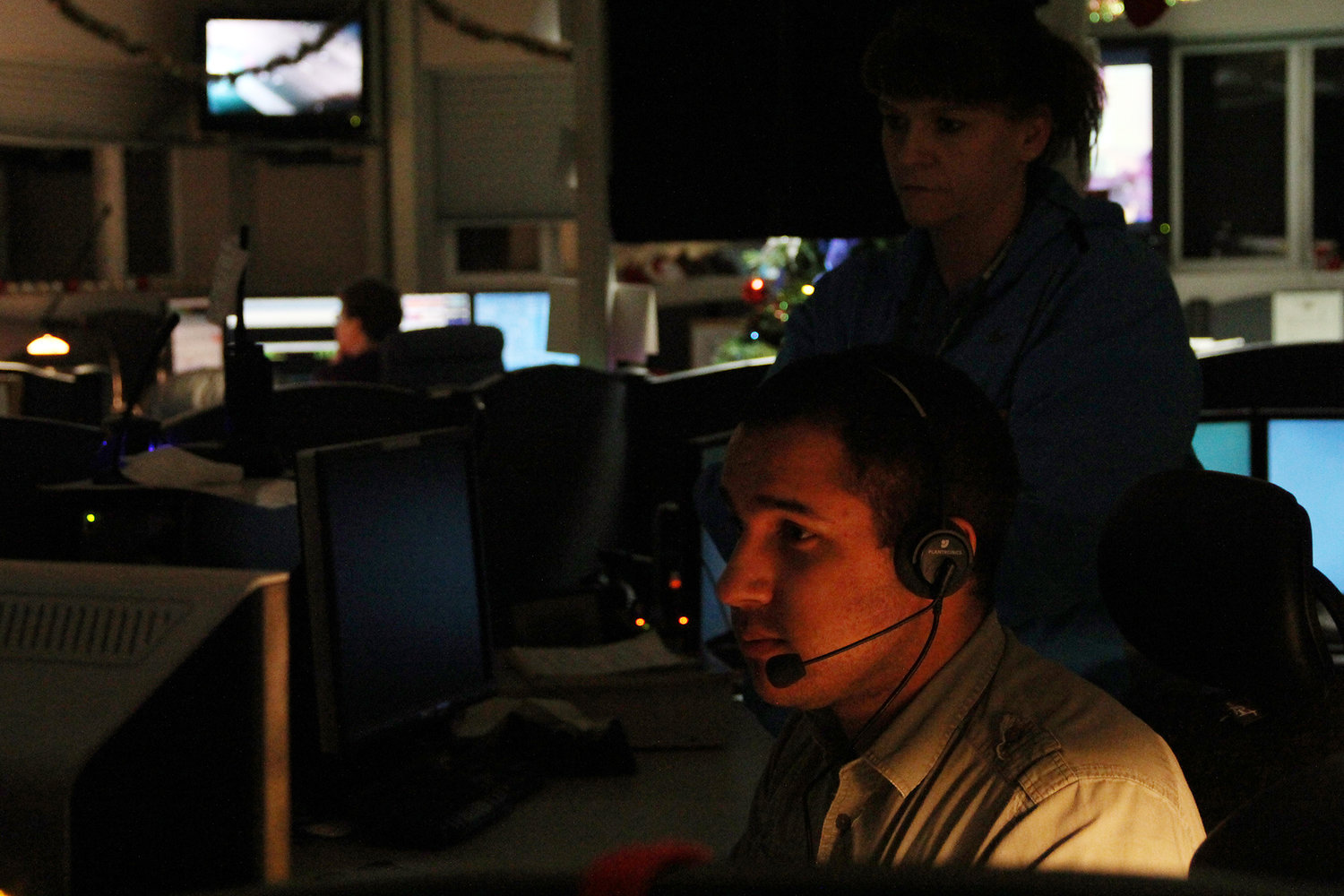 Kaylee Osowski / kosowski@chronline.com James Hatchett works his station at the Lewis County 911 Communications Center Thursday night in Chehalis as a coworker looks on. Hatchett began working at the center in July.