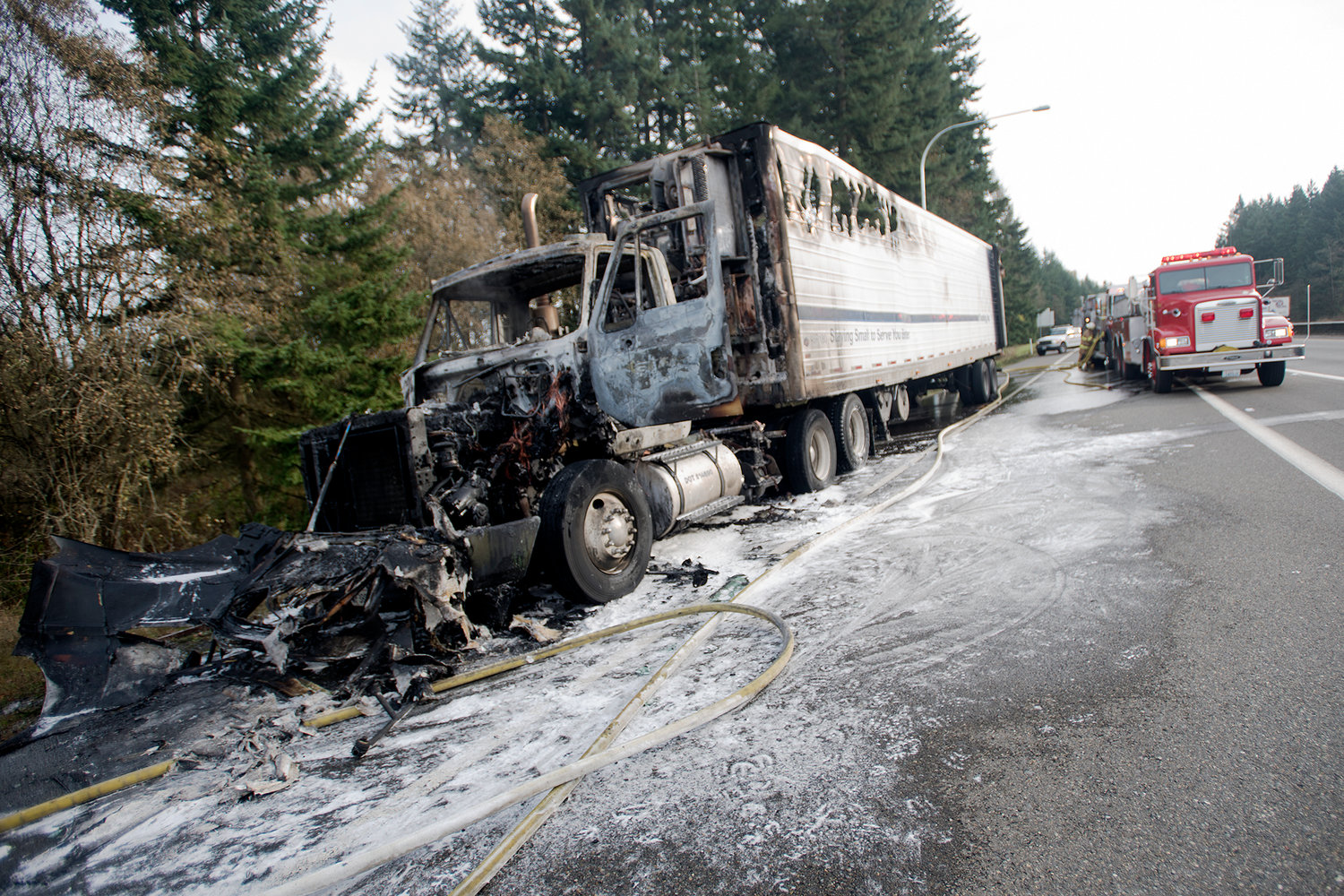 A charred semi truck that had caught fire along northbound Interstate 5 sits at exit 71 on Tuesday afternoon in Napavine. No one was injured in the blaze, which fire officials believed began with the refrigerator unit in the trailer.