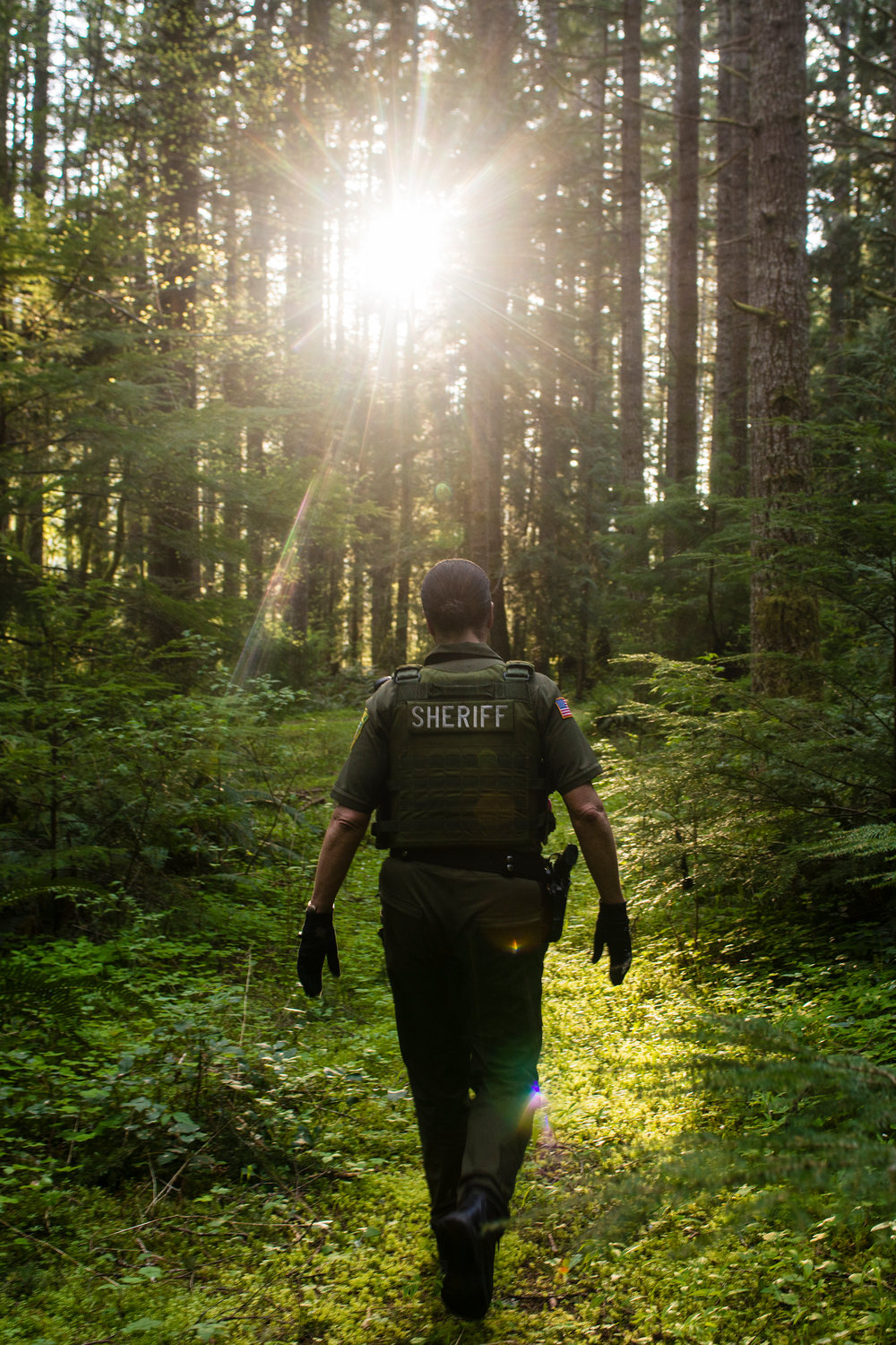 Lewis County Sheriff's Deputy Sue Shannon walks through the Pleasant Valley Wildlife Area towards Alder Lake where there was a report of over a dozen teenagers drinking along the shores. For 12 years Dep. Shannon has patrolled the largest area in Lewis County, a rugged landscape that stretches from Mossyrock in the west to White Pass in the east and goes as far north as Ashford and and as far south into the Gifford Pinchot National Forrest.