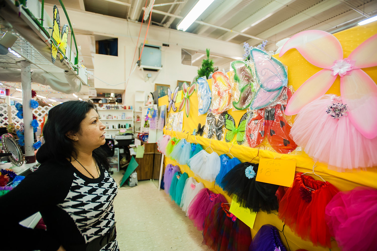 Rosa Romo looks at butterfly wings and tutus that hang on the wall of her booth at Yard Birds Shopping Mall in Chehalis on Tuesday, Feb. 25. Romo and her daughter, Nancy Hernandez, have rented the stall for about a year.