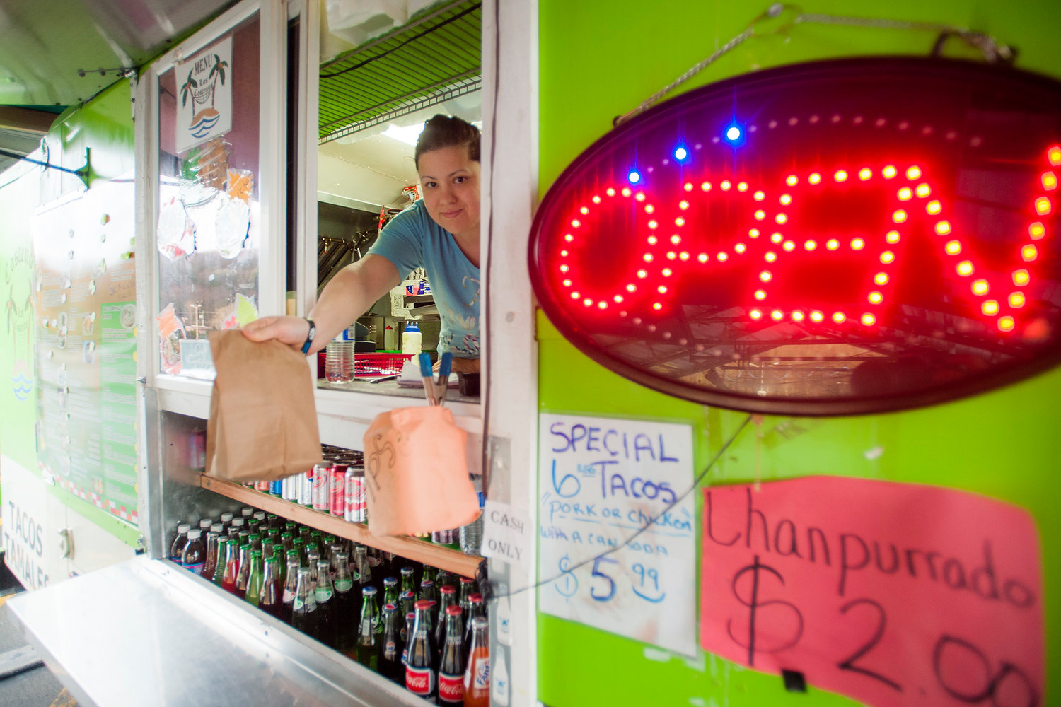Alicia Camba, owner of Los Costenos, hands a burrito out the window of her taco truck outside Yard Birds in Chehalis on Monday, March 3, 2014. Camba said that she has been open for nearly two years now at the same spot just outside the entrance to Shop 'N Kart.