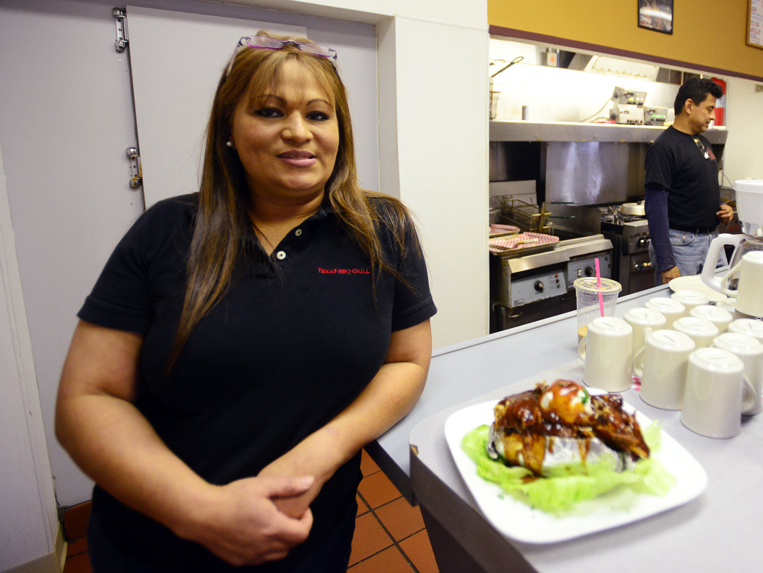 Brenda Salgado, owner of Texas BBQ Grill, leans against the counter next to her signature dish, the Terrific Tater, on Monday afternoon at the restaurant in Chehalis.