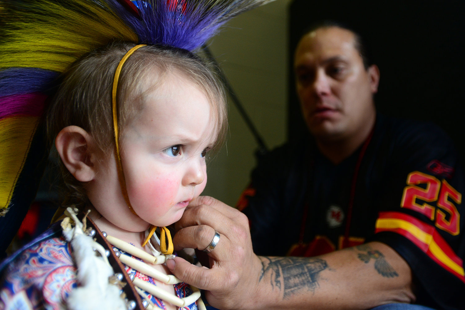 Owhi Littleleaf of Warm Springs, Ore., right, resizes the headdress strap for his son, Chayton, 1 1/2 years old, prior to the start of the intertribal dance at the 14th Annual Cowlitz Indian Tribe Pow-Wow at Toledo High School in Toledo, Wash., on Saturday, Sept. 21, 2013. Several hundred people attended the day-long event that featured dance contests, food vendors and raffles.