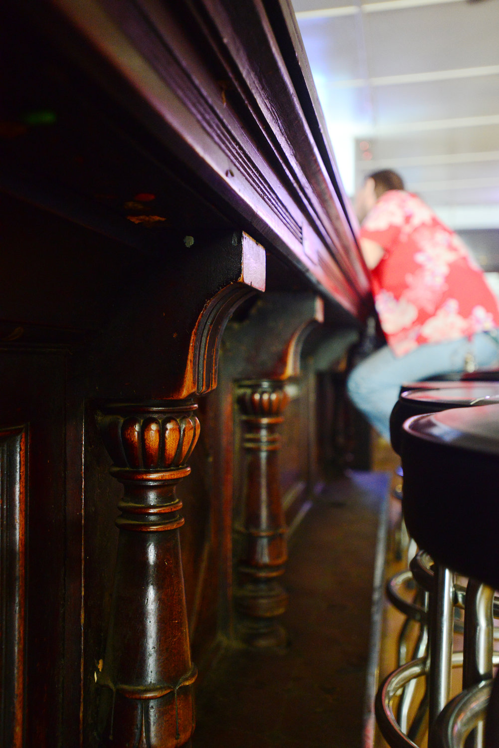 A patron of Joe's Place sits at the end of the 60-year-old black walnut bar top that was imported from Europe.