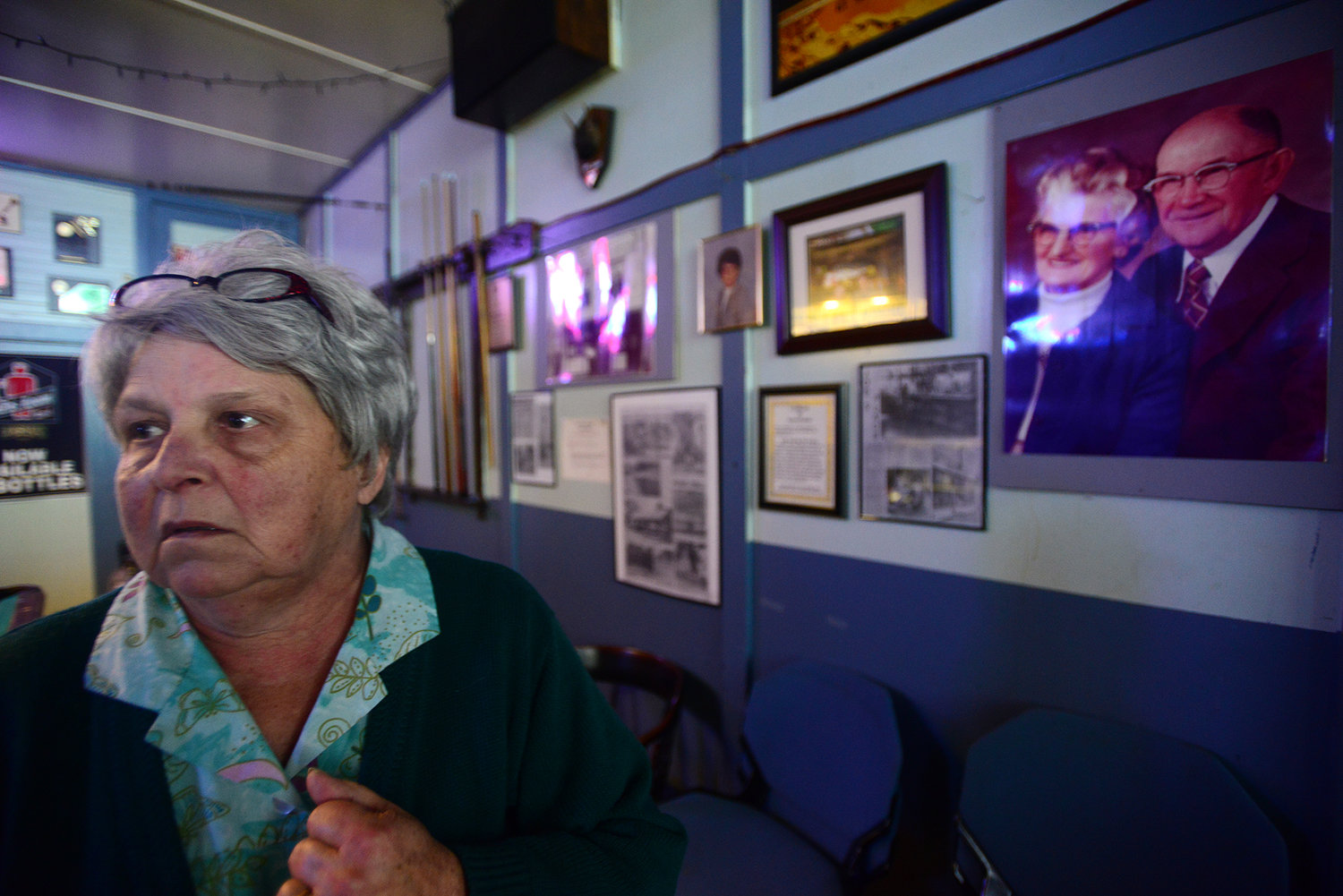 Judy Wall, the owner of Joe's Place in Bucoda, walks back towards the bar after showing the wall where pictures hang of the in-laws which owned and ran the bar since 1898.