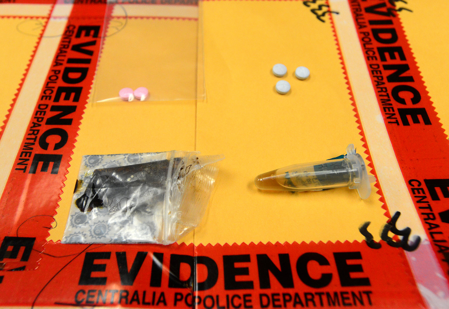 FILE PHOTO — Oxycodone pills, top, tar heroin, bottom left, and liquid heroin, is seen in the evidence department of the Centralia Police Department in this file photo.
