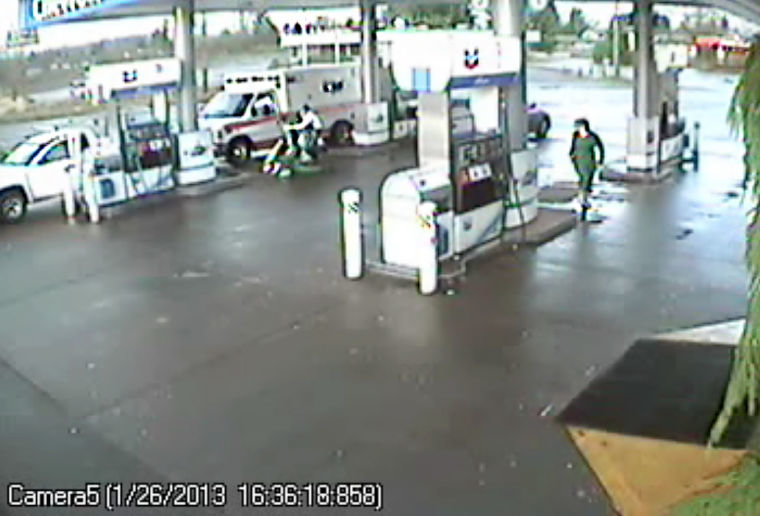 An Olympia man, identified as Wade C. Buchanan, 47, scuffles with American Medical Response paramedics on Saturday afternoon in this image taken from surveillance video at the Chevron gas station near Mellen Street.