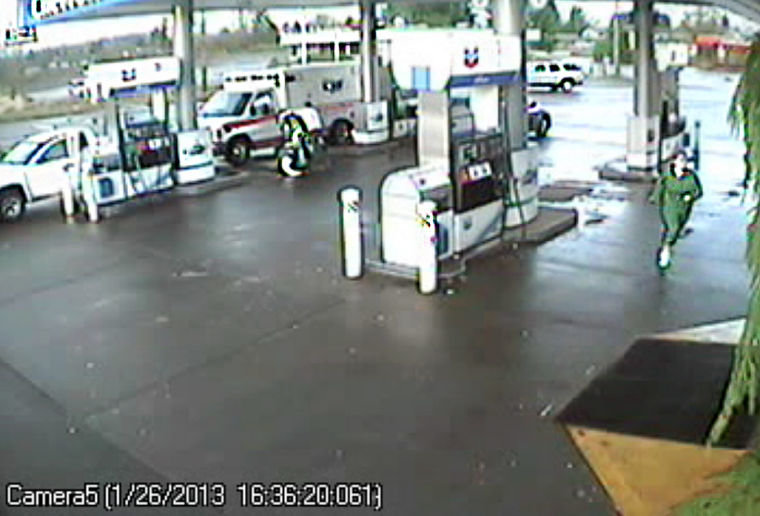 An Olympia man, identified as Wade C. Buchanan, 47, scuffles with American Medical Response paramedics on Saturday afternoon in this image taken from surveillance video at the Chevron gas station near Mellen Street.