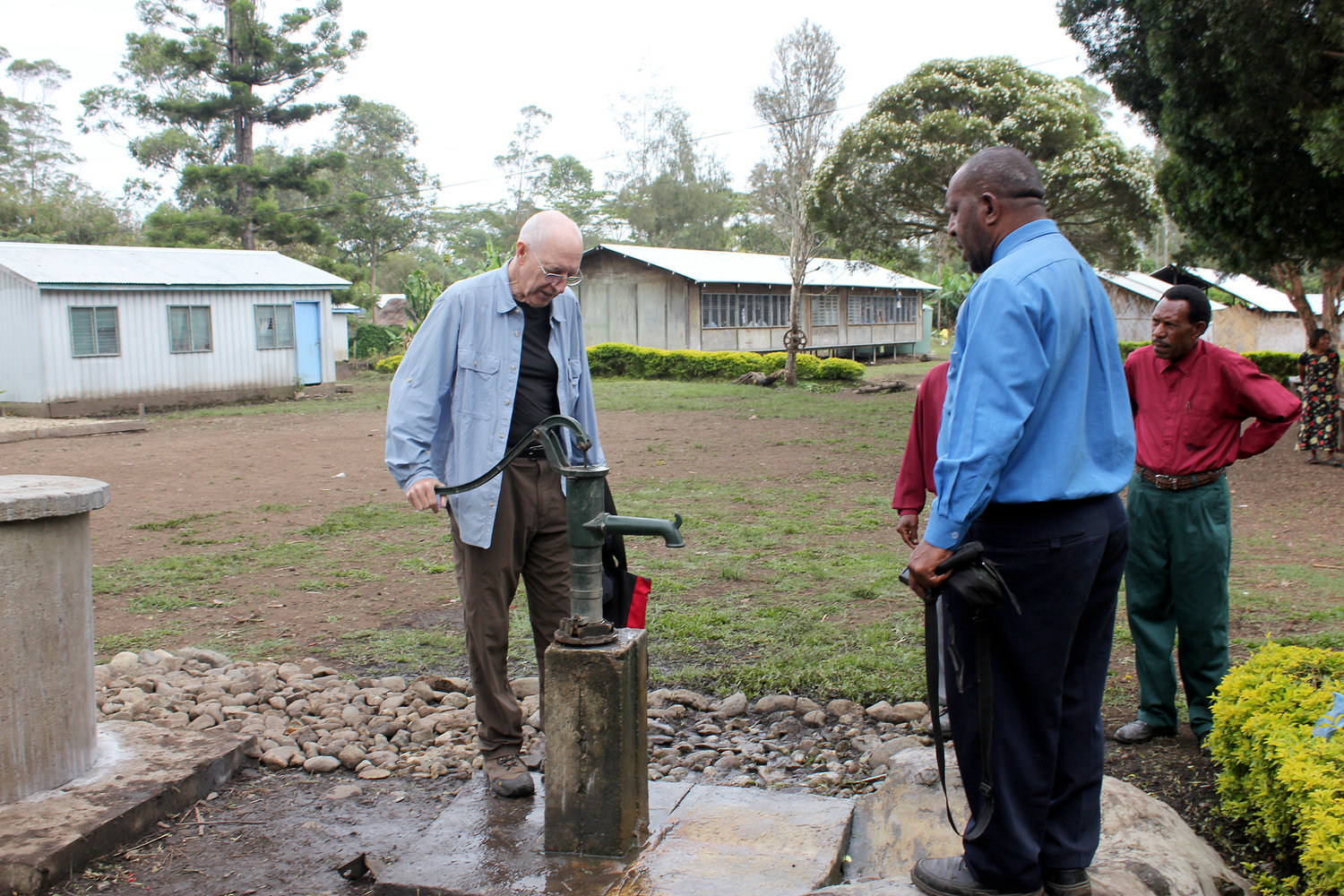 Dr. Larry Hull stands next to a new well that was built near a school in Papua New Guinea in October 2012. Hull and his wife, Aarlie, own a not-for-profit coffee plantation on the island and have built eight new wells around the area near their plantation.