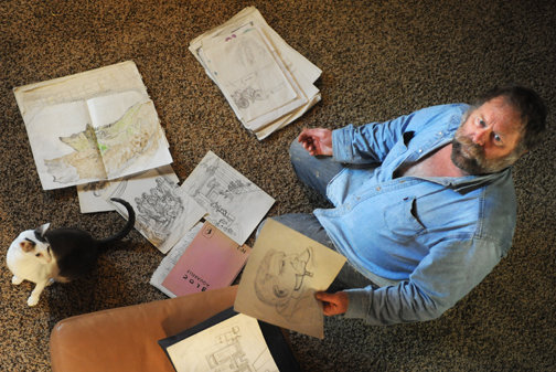 Hank Claycamp sits in his Centralia home in November of 2010 with some of his drawings from his travels around the world.