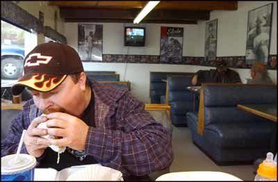 Gary J. Cichowski / The Chronicle Brad Cusson, Chehalis, takes a bite of his burger at Kalich's Dairy Dan's Drive In, in Chehalis, on Friday afternoon. The discovery of mad cow disease doesn't appear, so far, to have changed local dining habits.