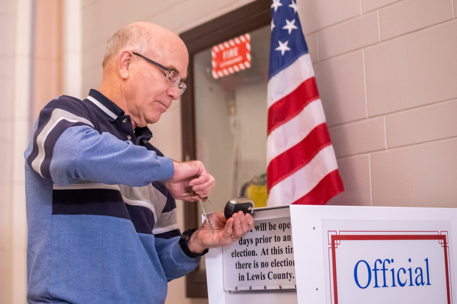 Lewis County Auditor Larry Grove locks up an official ballot box in this Chronicle file photo.