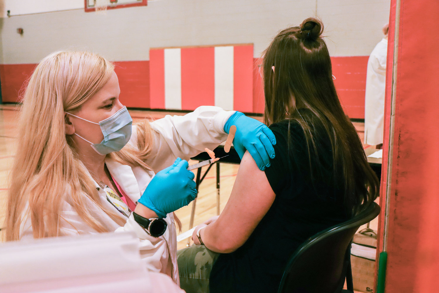 Melissa Clatone, LPM with the Chehalis Tribal Wellness Center, distributes vaccines in an Oakville School Gymnasium Friday morning.