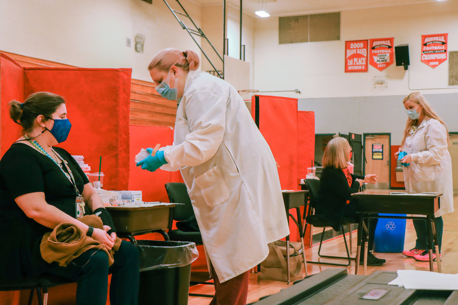 Medical professionals with the Chehalis Tribal Wellness Center prepare to distribute vaccines in an Oakville School Gymnasium earlier this month. 