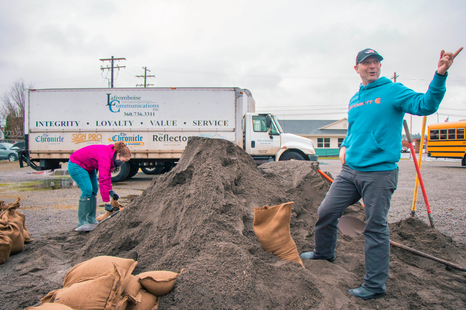 Peter Abbarno points to downtown Centralia while filling sacks with sand as community members prepared for storms and flooding in January.