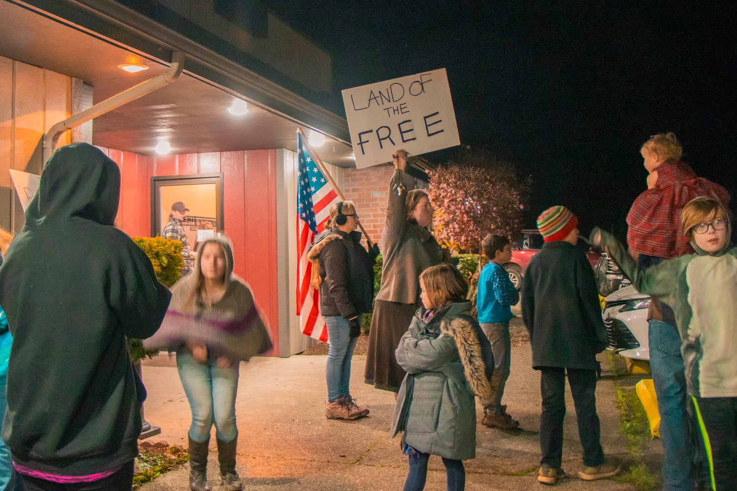 Community members hold signs and flags outside of Spiffy’s Restaurant and Bakery last year.