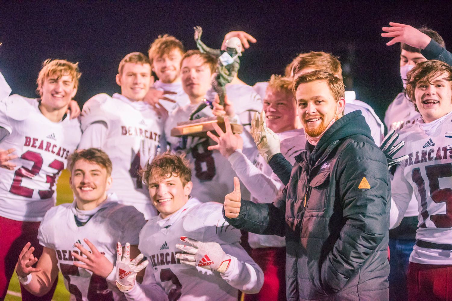 The Chronicle's Franklin Taylor poses with players and the Swamp Cup trophy following a game in Centralia Saturday night at Tiger Stadium.