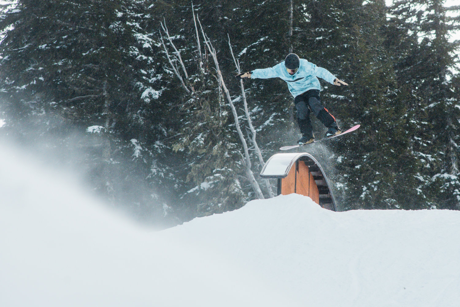 A snowboarder sticks the landing at the Ribeye jump park inside the White Pass Ski Area on Sunday.