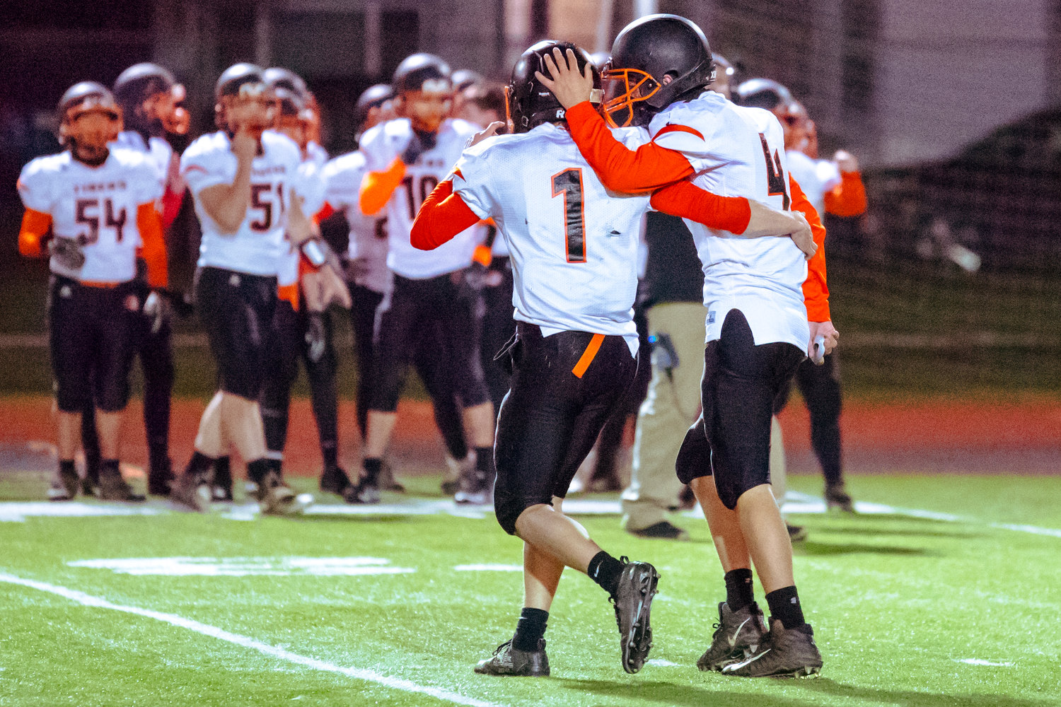 Tigers embrace following a play during a game against Onalaska Saturday night at Tiger Stadium.