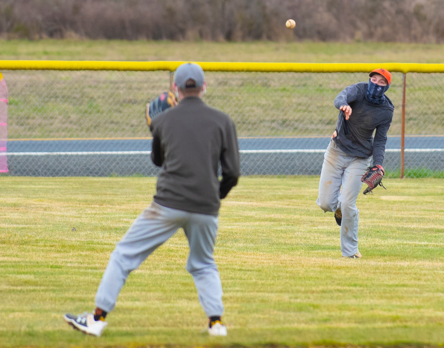 Winlock junior Chris Heikkila, right, throws to his cutoff man from right field during practice on March 19.