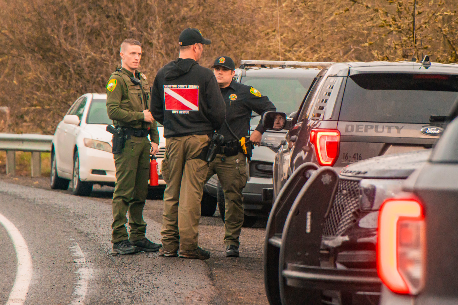 A member of the Thurston County Sheriff Dive and Rescue crew speaks to deputies along Highway 603 near the Chehalis River in Adna.