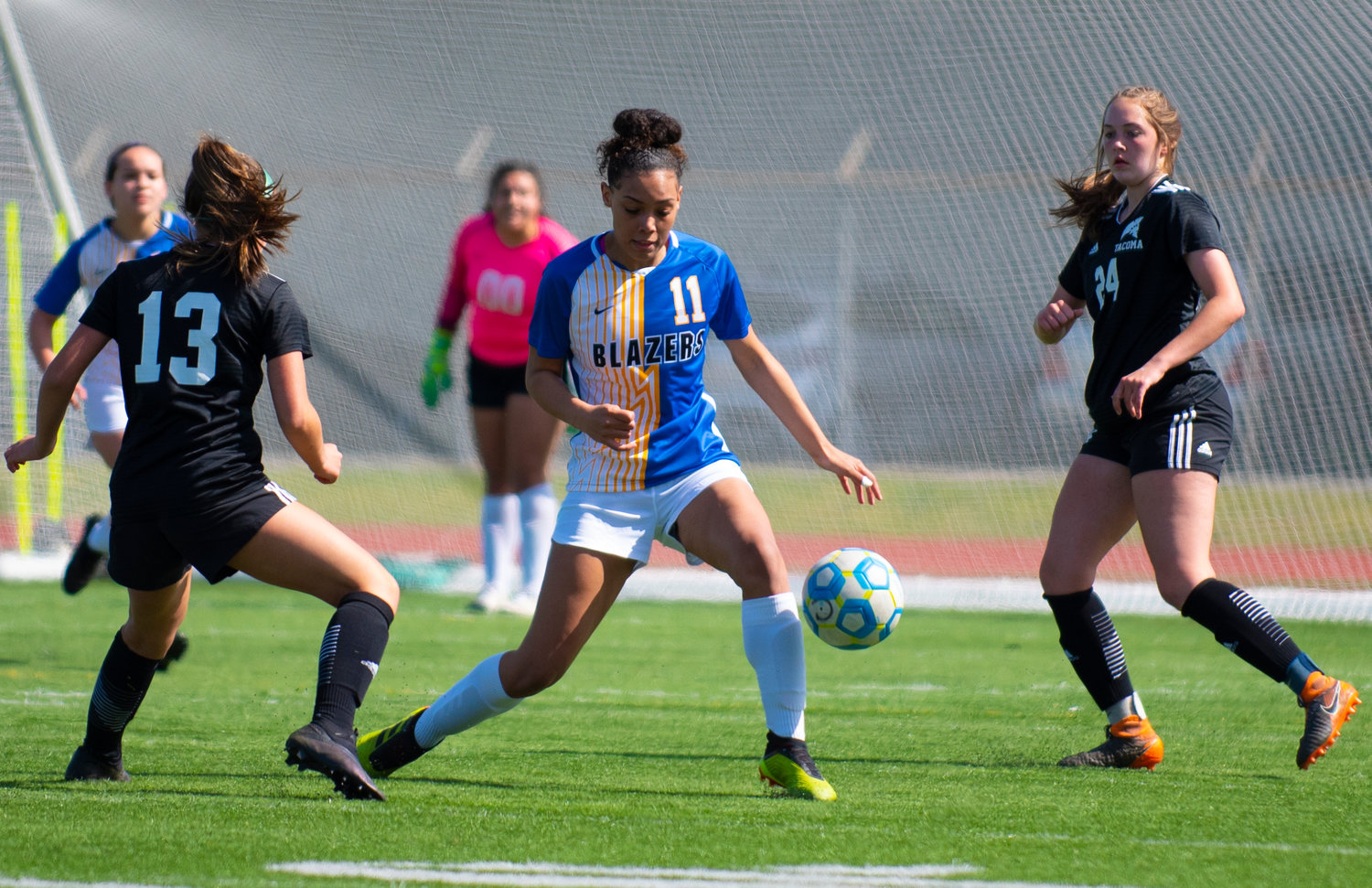 Centralia College freshman Imani Tustison (11) works the ball against Tacoma forwards on Tuesday at Tiger Stadium.
