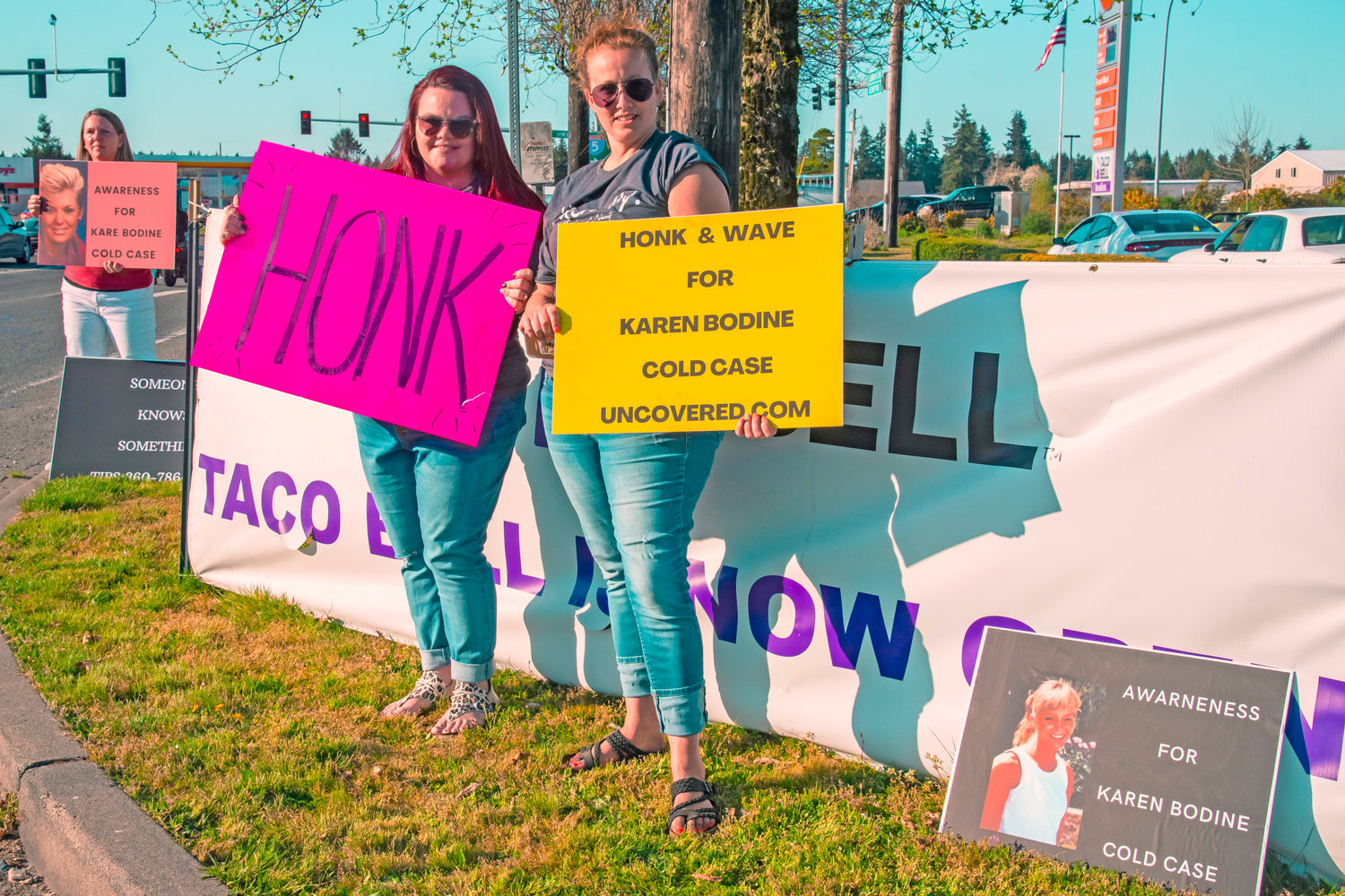 Whitney St. Andre, center left, and Melissa Leinweber hold signs during a honk and wave event in Grand Mound on Saturday.