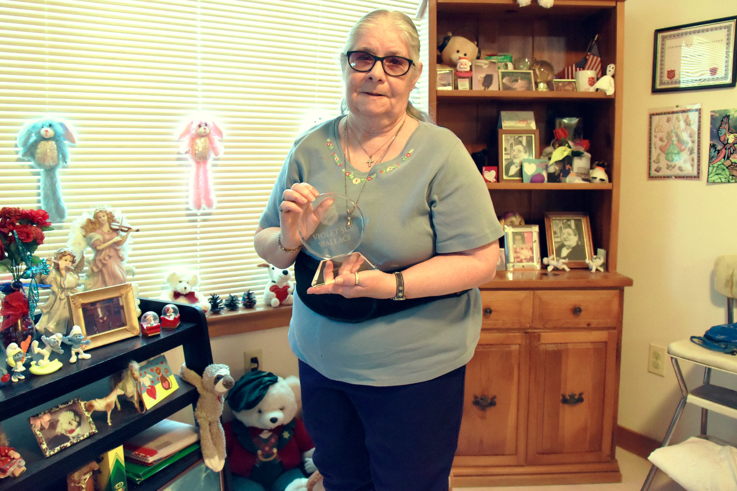 Sue Wallace holds up and talks about an award from the Salvation Army she has displayed in her Centralia home.