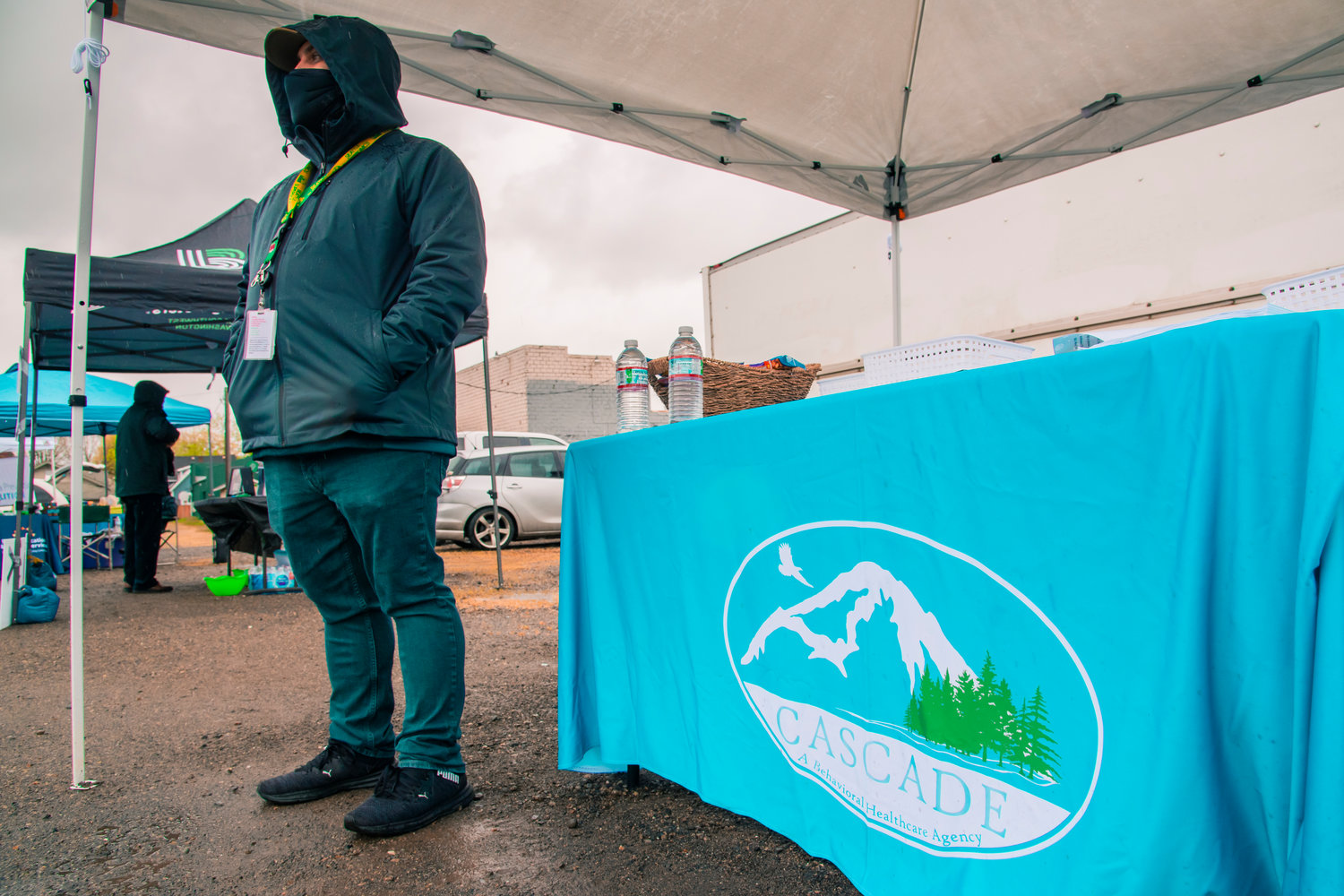 Stetson McElhaney stands at a tent for Cascade Behavioral Health as they provide resources at a drive-through site in Centralia on Saturday for National Drug Take Back Day.