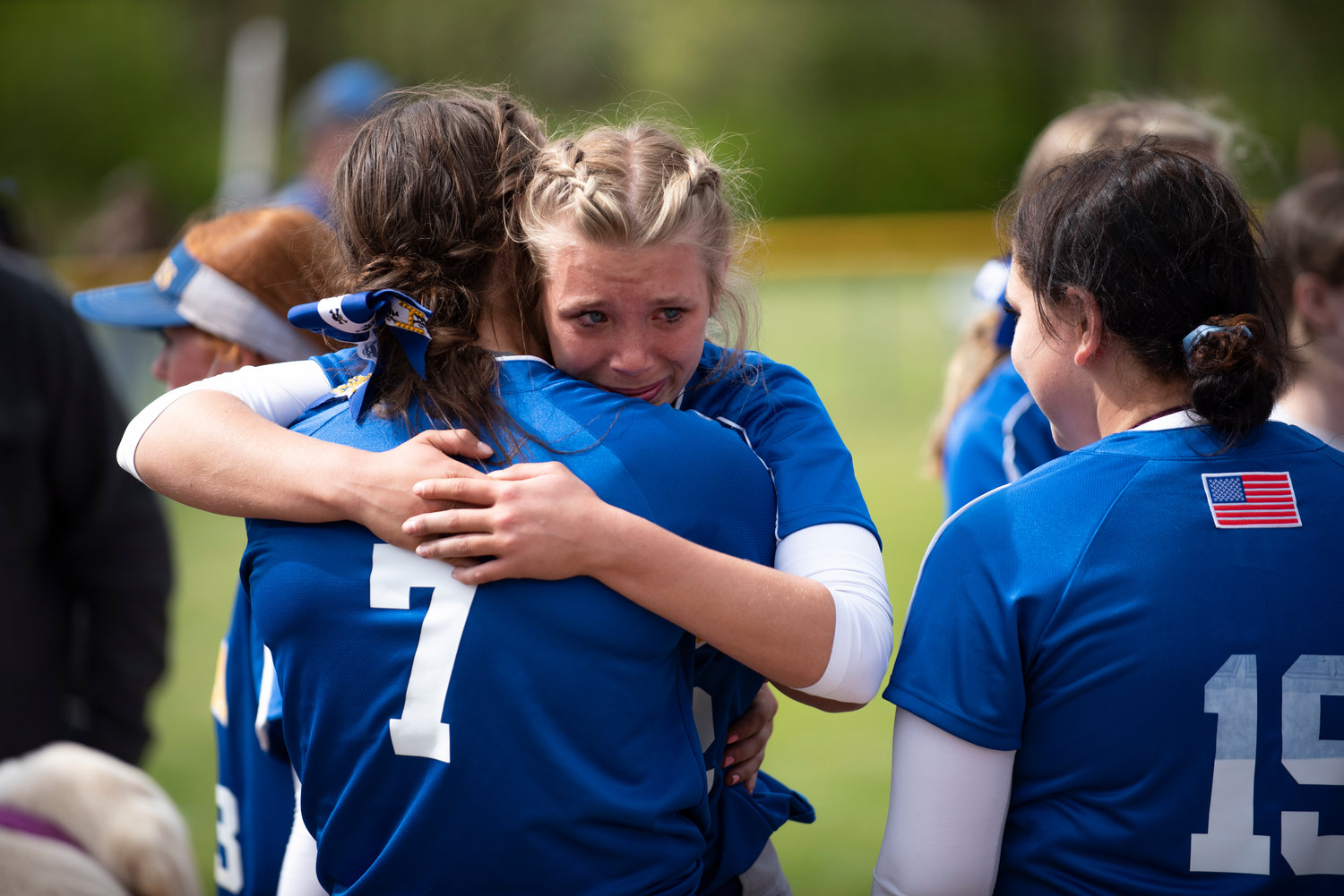 Adna eighth graders Ava Simms hugs senior Haley Rainey (7). Simms scored the game-winning run against Forks from Rainey's walk-off single in the 2021 district championship Saturday in Adna.