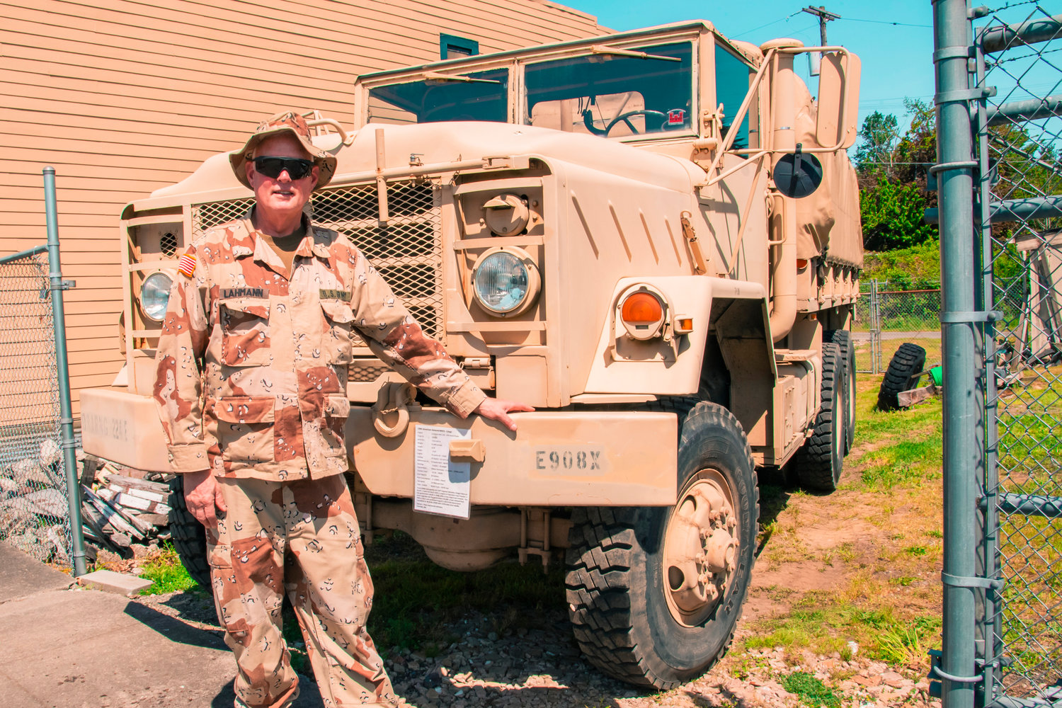 Peter Lahmann poses for a photo sporting desert gear next to a military vehicle he owns and drives through downtown Centralia.