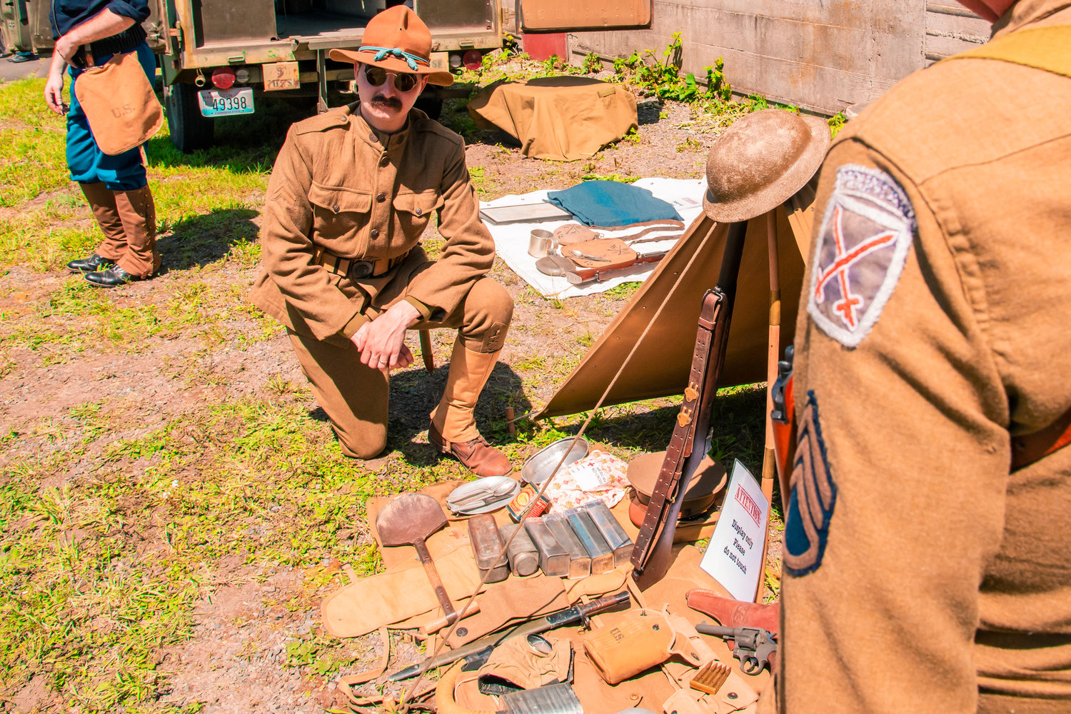 Brian Hunt with PNW Great War kneels down while talking about his WW1 military collection on Armed Forces Day in Centralia 2021.