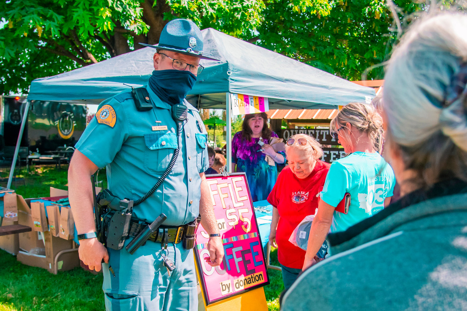 J.T. Ausborn with the Washington State Patrol mingles with attendees near a raffle table during a “Back The Blue” event on Saturday outside the Adna Burger Bar.