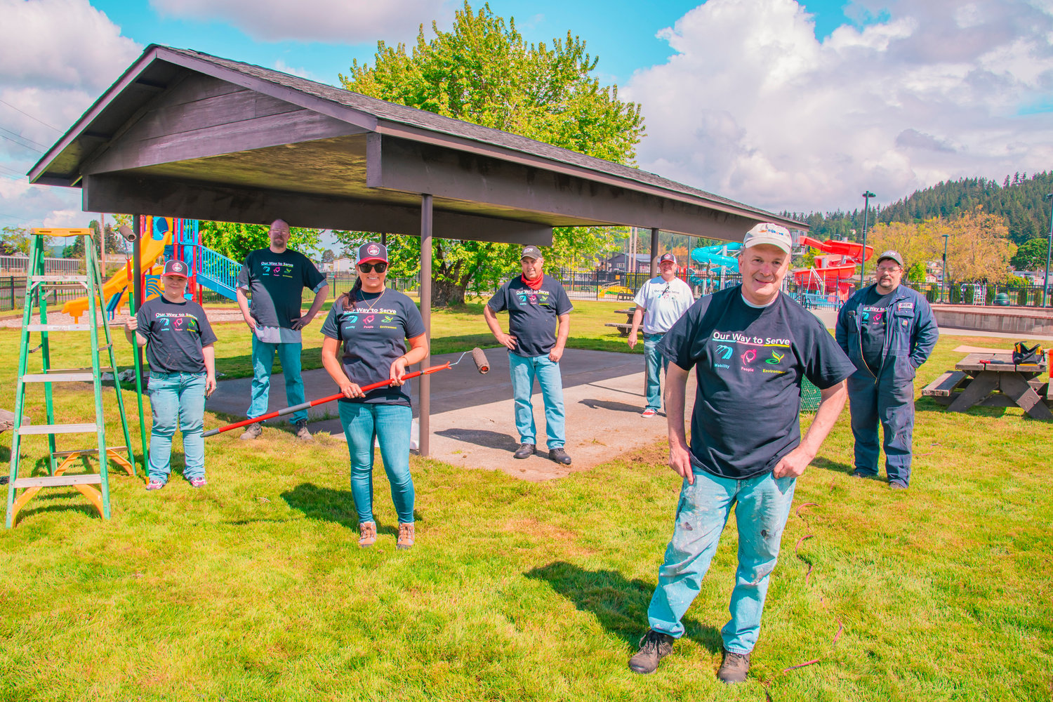 From left to right, Angela Henderson, Jesse Coffman, Amanda Hubbert, Darren Soares, Donny McReynolds, Larry Barstow, and Dary Estep, with GCR Tires and Service, pose for a photo in Chehalis after painting a covered area at the park near the Gail and Carolyn Shaw Aquatics Center Wednesday morning during their third community based project.