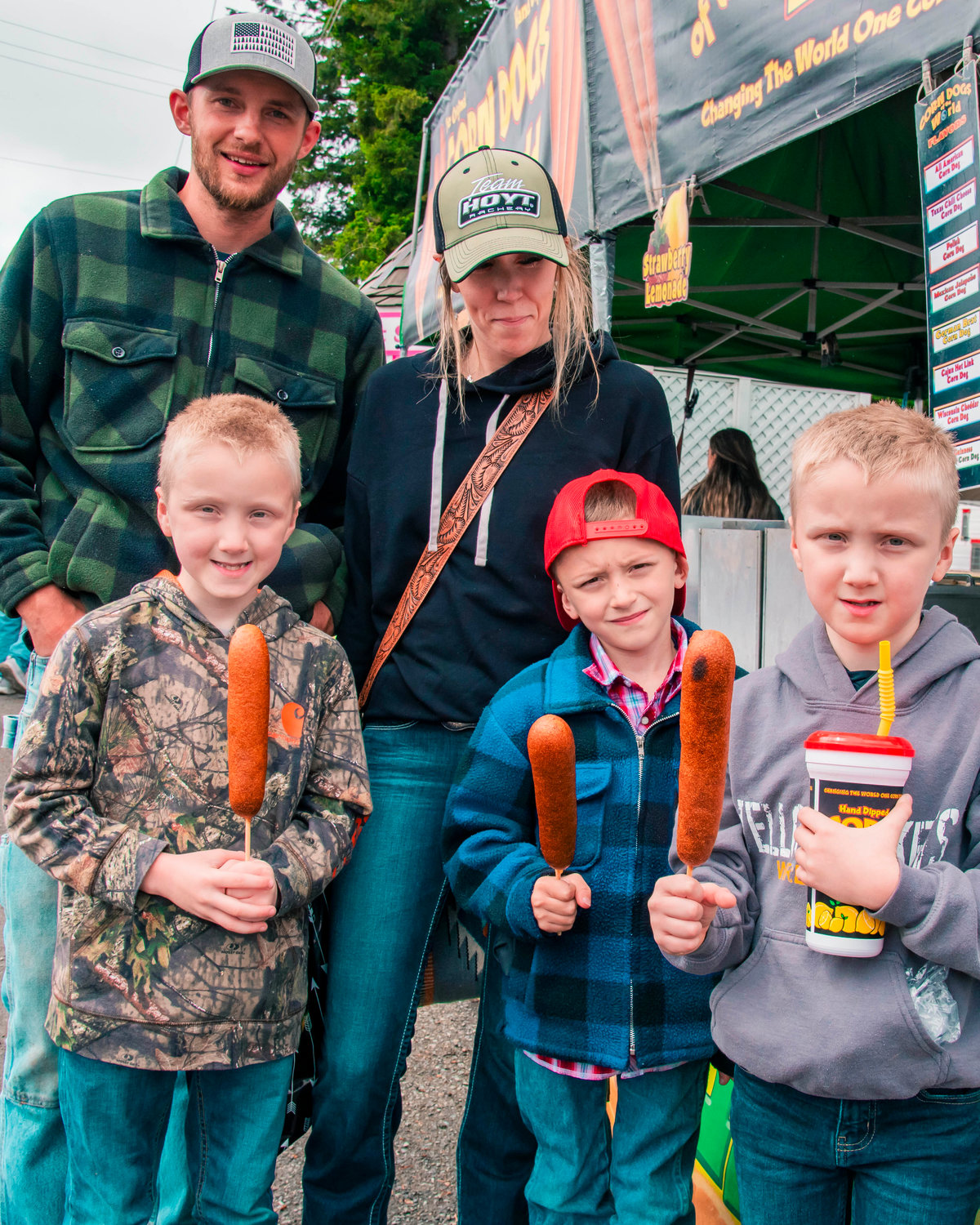 Members of the Southworth Family hold up corn dogs during their first visit to the Packwood Flea Market Friday morning.